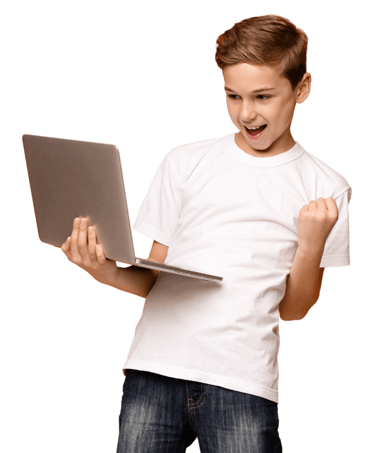 Uczeń zaciska pięść z uśmiechem, patrząc na ekran laptopa